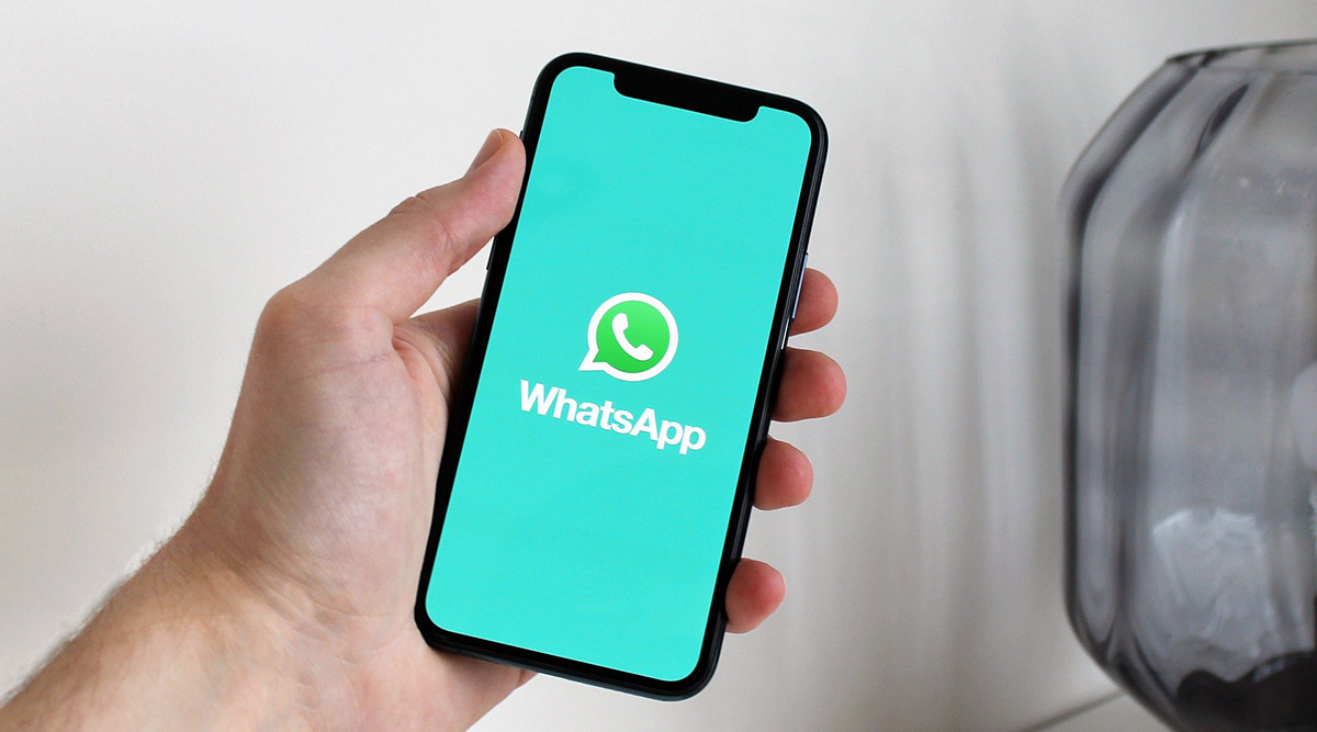 This picture shows a man holding an iOS device with WhatsApp on it. The new beta function will allow users to hide their last seen from specific contacts