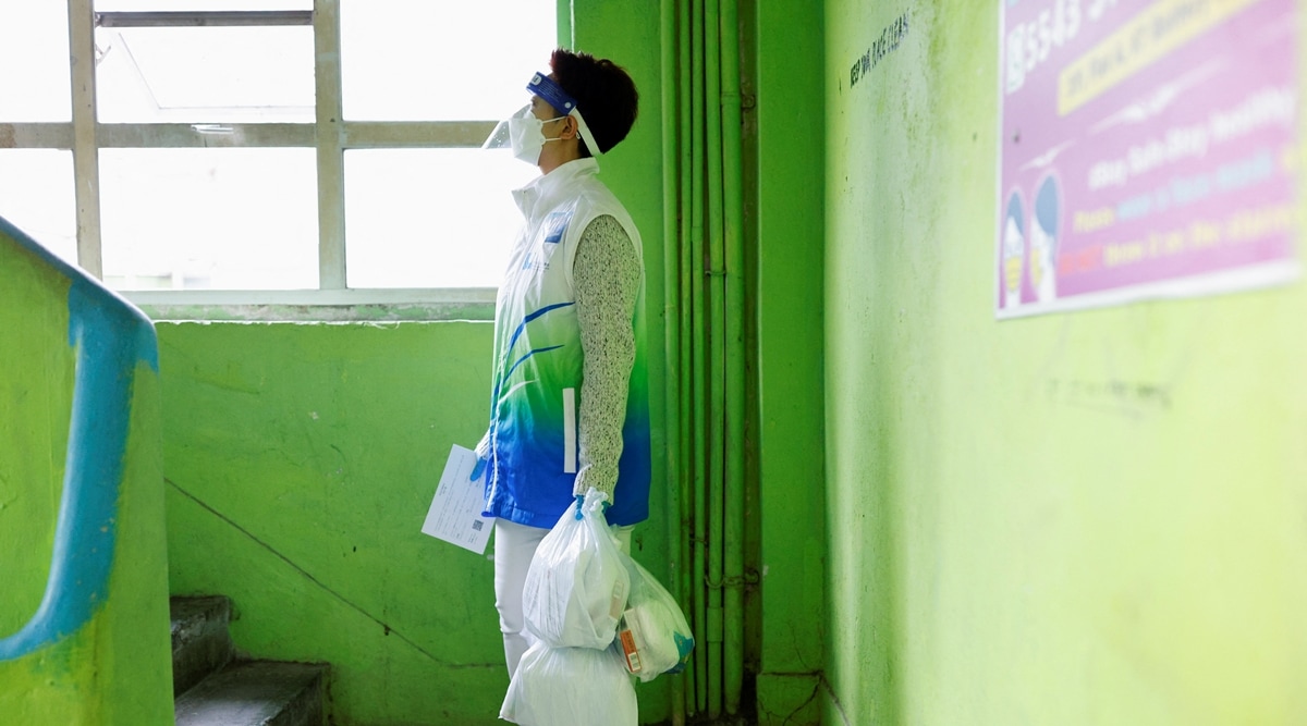 A volunteer holds anti-epidemic bags as she delivers them to residents during the Covid-19 pandemic, in Hong Kong, China, April 2, 2022. (Reuters)