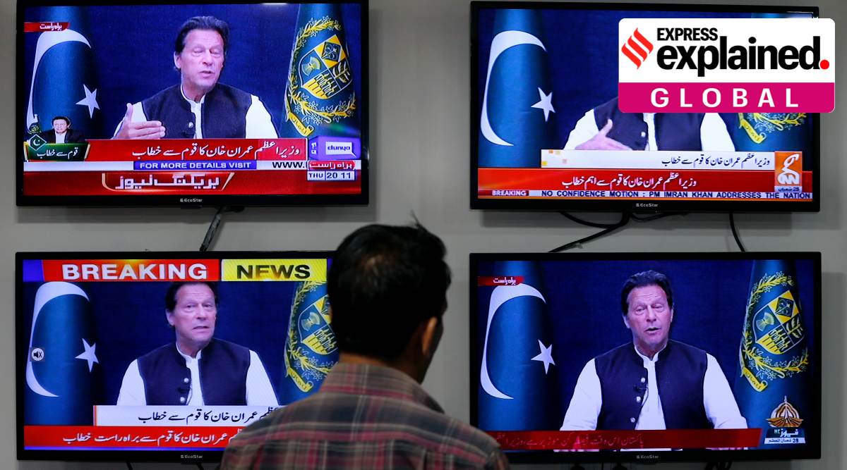 A man watches news channels broadcast a live address to the nation by Pakistan's Prime Minister Imran Khan, in Islamabad, Pakistan, Thursday, March 31, 2022. (AP Photo/Anjum Naveed, File)