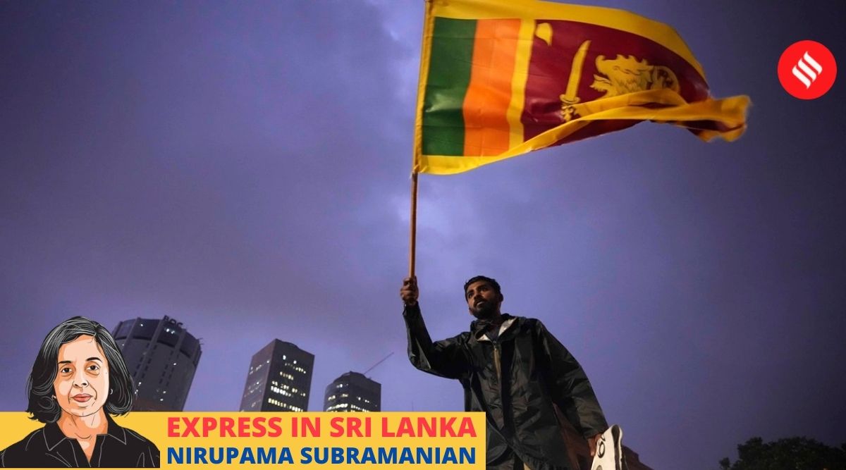 A man waves a Sri Lankan national flag as he stands on a barricade blocking the entrance to president's office during a protest in Colombo, Sri Lanka, April 11, 2022. (AP)