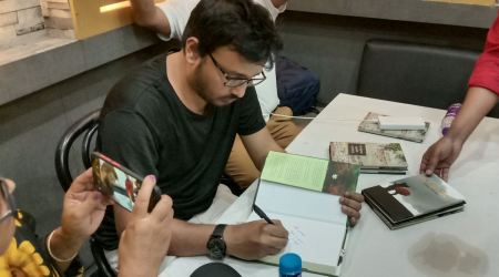 Sadat Hossain signs his books for readers. (Express Photo)