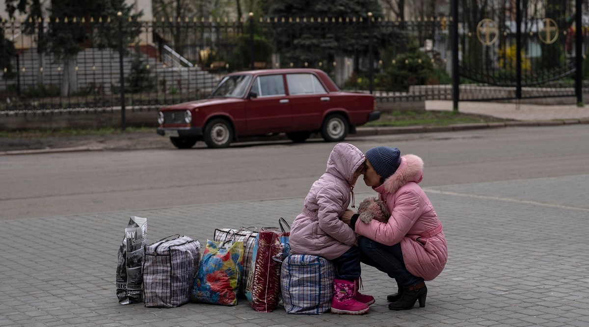 A mother hugs her daughter as they wait for a bus to flee from Sloviansk city, in Donetsk district, to travel to Rivne, western Ukraine. (AP)