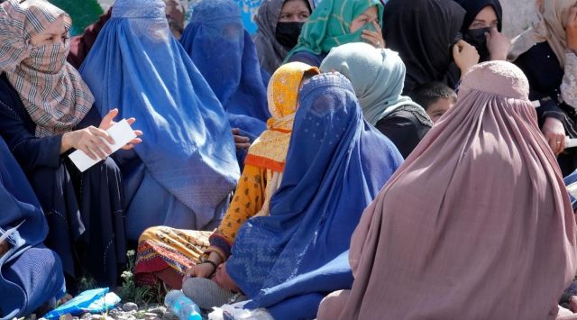 Afghan women wait to receive food rations distributed by a Saudi humanitarian aid group, in Kabul, Afghanistan, Monday, April 25, 2022. (AP Photo/Ebrahim Noroozi)