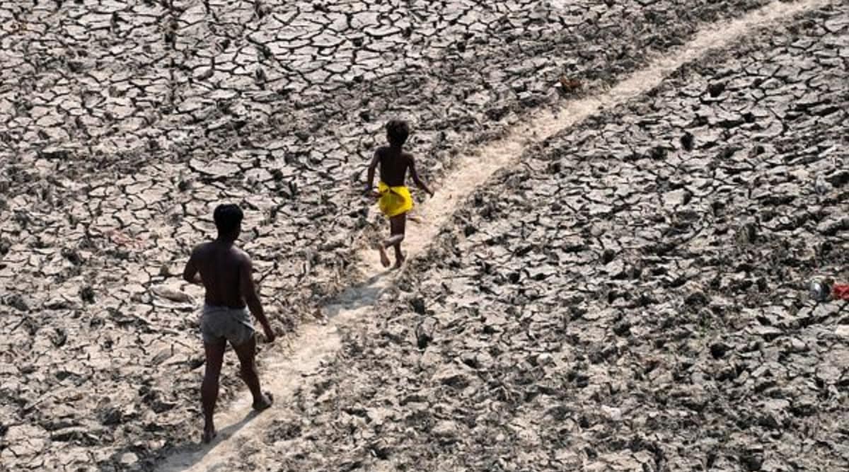 A man and a boy walk across an almost dried up bed of river Yamuna following hot weather in New Delhi, India, Monday, May 2, 2022. (AP Photo)
