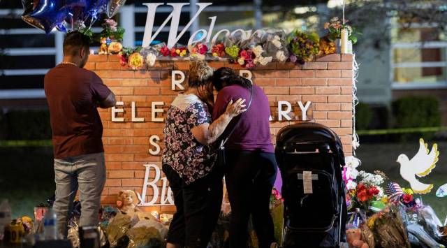 Elida Gonzales clings to her daughter, Amber Gonzales, as Amber Gonzales’ husband, Albert Martinez and their daughter Nyla Martinez, six months old, look on at a memorial set up outside Robb Elementary School, the site of a mass shooting, in Uvalde, Texas. (Reuters)