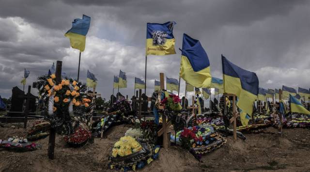 Ukrainian flags fly above graves at the military cemetery in Kharkiv, Ukraine. (Finbarr O'Reilly/The New York Times)