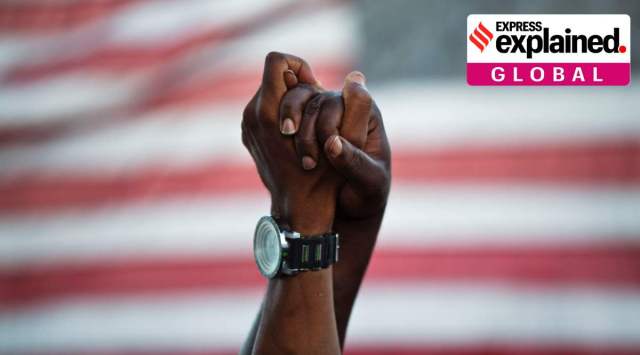 People join hands against the backdrop of an American flag. (AP Photo/David Goldman, File)