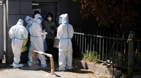Workers in protective suits prepare to collect swabs from people near a sealed off market amid the coronavirus disease outbreak in Beijing, China. (REUTERS)
