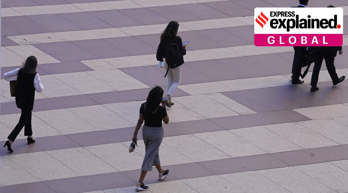Women walk towards an office building in Madrid, Spain, Tuesday, May 17, 2022. (AP Photo/Paul White)