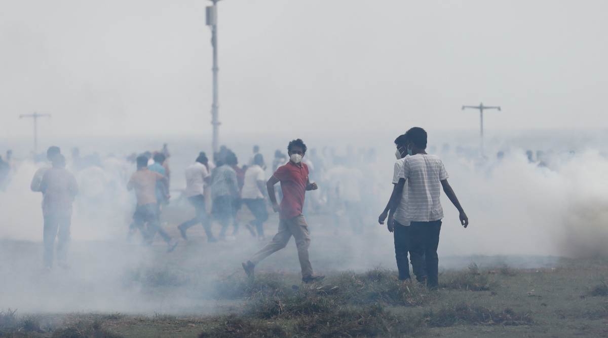 Supporters of Sri Lanka's ruling party run as riot police fire tear gas during a clash with anti-government demonstrators, amid the country's economic crisis, in Colombo. (Reuters)