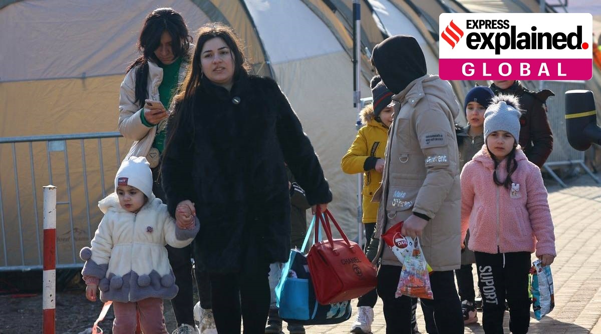 People walk beside tents after crossing the border from Ukraine to Poland, fleeing the Russian invasion of Ukraine, at the border checkpoint in Medyka, Poland. (File/Reuters)