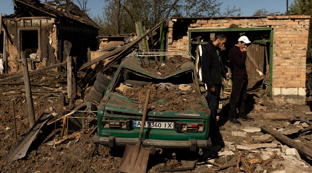 Men react as they stand in front of their house after a missile strike hit a residential area, amid Russia's invasion in Ukraine, in Bakhmut in the Donetsk region, Ukraine, May 7, 2022. (Reuters)