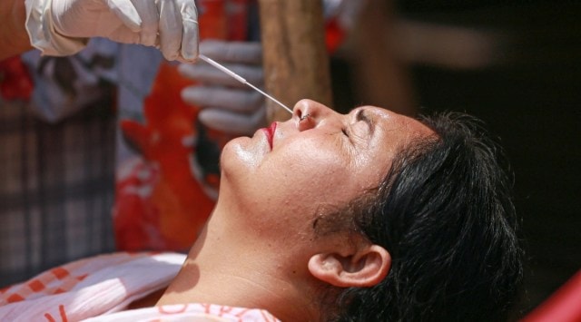 A healthcare worker conducts Covid-19 testing of a woman as coronavirus case surge countrywide, in Jammu. (PTI, file)
