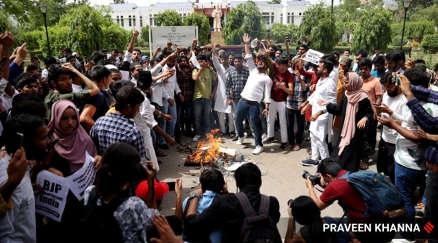 Protesters burn an effigy of ex-BJP spokesperson Nupur Sharma outside the gate of Jamia Millia Islamia University in New Delhi on Friday. (Express Photo: Praveen Khanna)