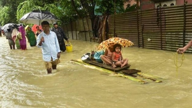People using a banana raft to move to a safe place at a flood-hit village in Nalbari district of Assam. (PTI Photo)