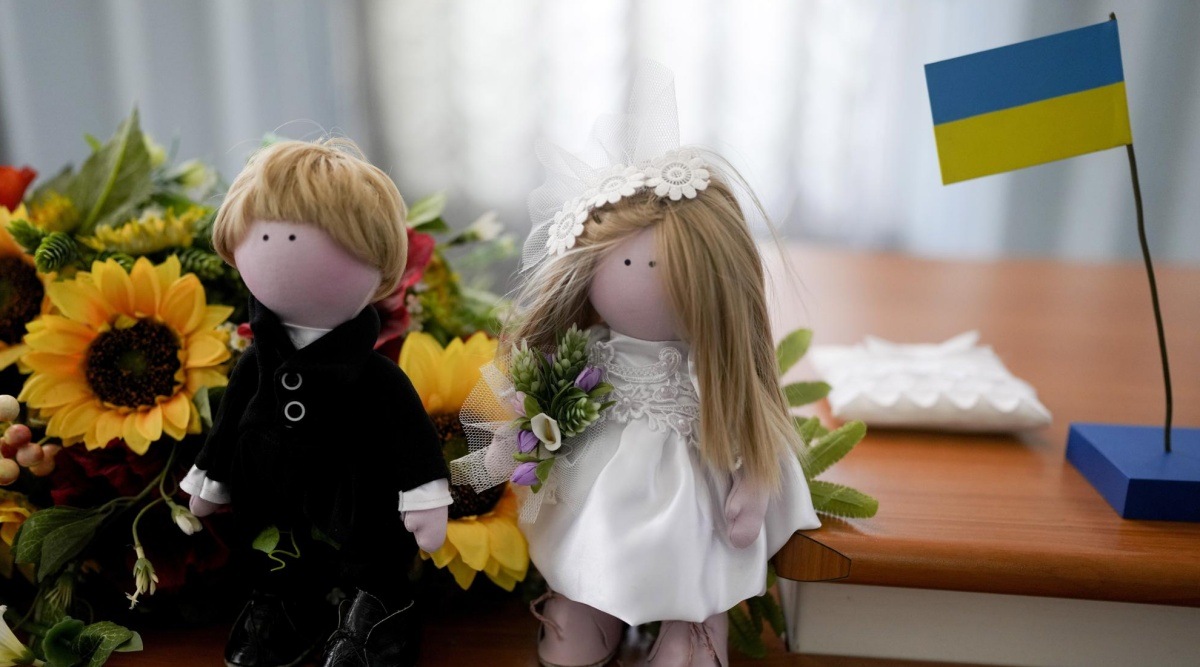 Dolls representing the bride and groom decorate a table at a civil registry office in Kyiv, Ukraine, Wednesday, June 15, 2022. (AP Photo/Natacha Pisarenko)