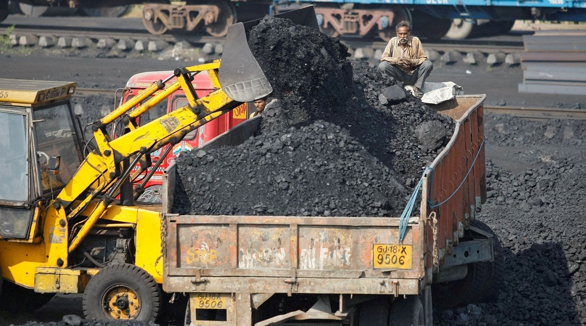 A worker sits on a truck being loaded with coal at a railway coal yard on the outskirts of the western Indian city of Ahmedabad. (REUTERS, file)
