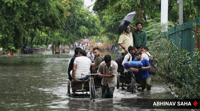 People paying 15 Rs per person to Thela Gaadi, to cross the waterlogged street in Tughlakabad, in New Delhi on Thursday, June 30, 2022. 
