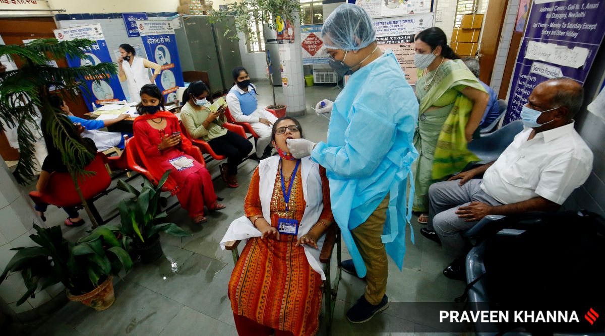 A health worker takes swab sample to test for Covid-19 in New Delhi. (Express Photo: Praveen Khanna, File)