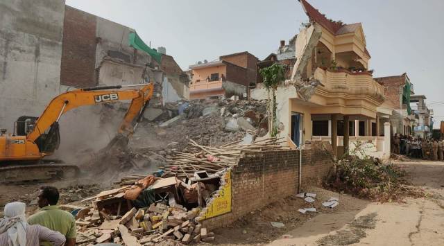 A bulldozer tears down the house of activist Mohammad Javed in Prayagraj on Sunday. (Express photo by Ritesh Shukla)
