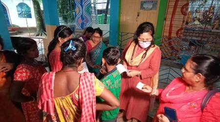 A doctor checks on people at the relief camp set up at Radhamadhab temple. (Express Photo: Debraj Deb)