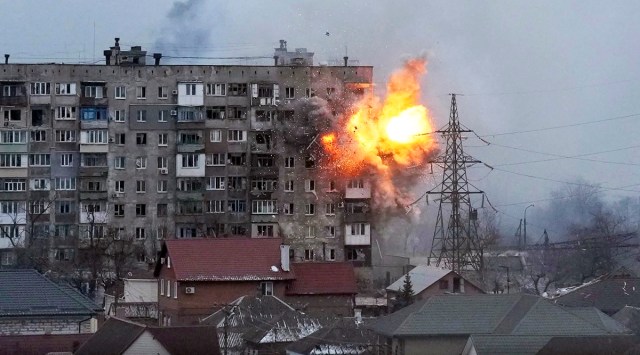 An explosion tears a hole in the side of an apartment building after a Russian tank fired a rocket in Mariupol, Ukraine. (AP, file)