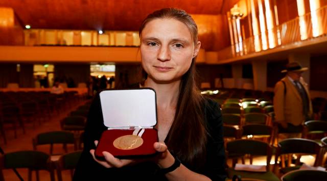 Maryna Vjazovska shows the Fields medal she was awarded Tuesday along with Maryna Vjazovska, James Maynard, June Huh and Hugo Duminil-Copin (AP photo)