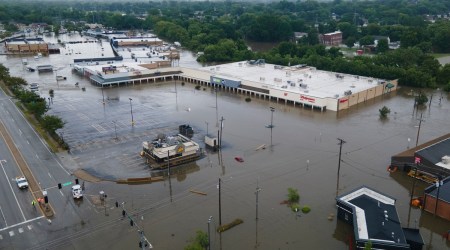 A flooded road and shopping area near Coldwater Creek in Florissant, Mo., July 26, 2022. (Michael B. Thomas/The New York Times)