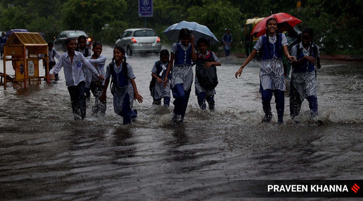 Children play in the rain while coming back from school in New Delhi on Wednesday. (Express Photo by Praveen Khanna)