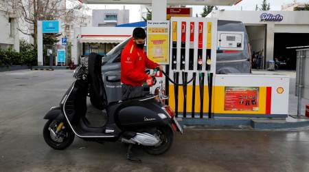 A worker fills a Vespa scooter at a gas station in Athens, Greece, March 17, 2022. (REUTERS/File Photo)