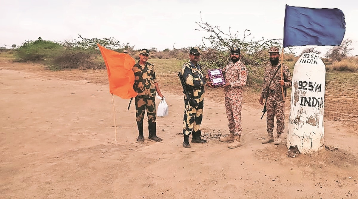 Officers of the Border Security Force exchange sweets with Pakistani Rangers on the border on Sunday. (Express Photo)