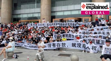 Demonstrators hold banners during a protest over the freezing of deposits by rural-based banks, outside a People's Bank of China building in Zhengzhou, Henan province, July 10, 2022. (Reuters)