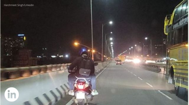 man working on flyover, man working on bike, man uses laptop on bike, indian express