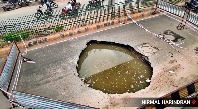 A road near metro pillar 129 caved in creating a massive ditch at Vastral on Sunday. (Express Photo)