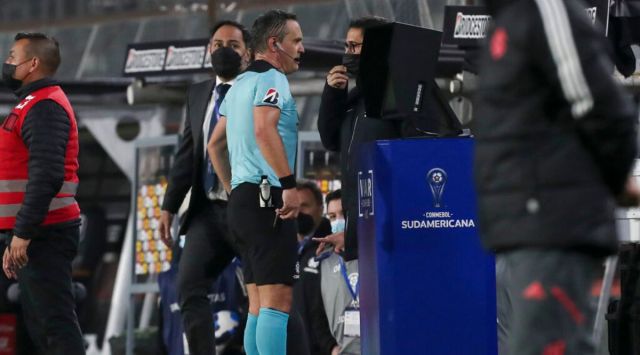 Referee Patricio Loustau of Argentina checks the VAR during a Copa Sudamericana soccer match between Chile's Colo Colo and Brazil's Internacional in Santiago, Chile, Tuesday, June 28, 2022. (AP Photo/Luis Hidalgo)