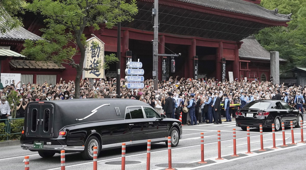 The vehicle, left, carrying the body of former Japanese Prime Minister Shinzo Abe leaves Zojoji temple after his funeral in Tokyo on July 12, 2022. (AP)