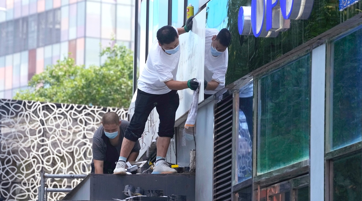 Workers renovate a signage at a mall, July 13, 2022, in Beijing. China's economic growth plunged to 0.4% over a year earlier in the latest quarter after Shanghai and other cities were shut down to fight coronavirus outbreaks, but the government said a "stable recovery" is underway. (AP)