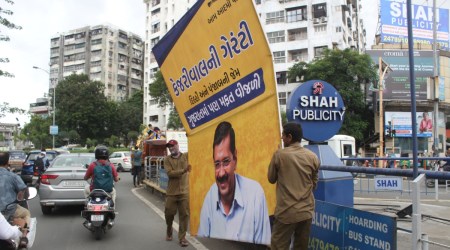 Surat Municipal Corporation staff remove banners of Delhi CM Arvind Kejriwal from Katargam area Thursday.  (Express Photo)