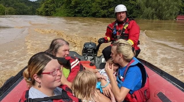 A rescue team member evacuates residents from their homes in a boat through flooded streets, in Breathitt County, Kentucky, U.S., July 28, 2022. (Wolfe County Search & Rescue Team/Handout via REUTERS)