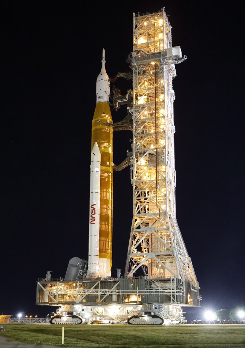 Spectators watch a sunrise from the Max Brewer Bridge while waiting to view  the launch on Pad 39B for the Artemis I mission to orbit the moon at the  Kennedy Space Center