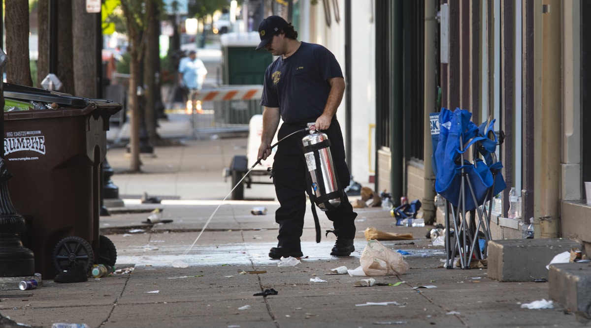 A fireman cleans blood off the sidewalk in Cincinnati, following an overnight shooting. (Liz Dufour/The Cincinnati Enquirer via AP)