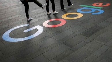 Employees pose for photos with a Google logo outside their office, in Singapore