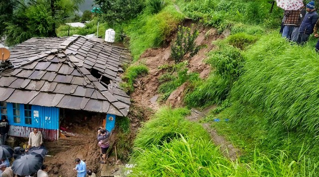 People near a damaged house following flash flood triggered by incessant monsoon rains in Ani subdivision of Kullu, Thursday, Aug 11. (PTI)
