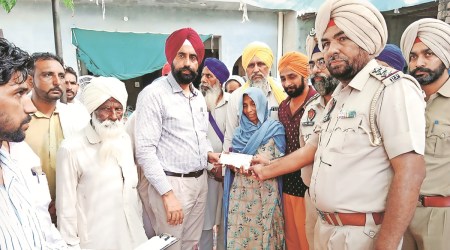 Kulwant Kaur, the widow of Balwinder Singh, being presented a cheque for Rs 3 lakh at her house in Raike Kalan village on Tuesday. (Express Photo)