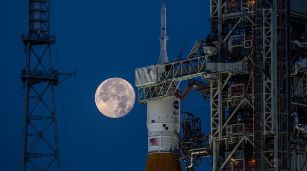 Полная луна за ракетой Space Launch System и космическим кораблем Orion во время испытаний миссии Artemis I.