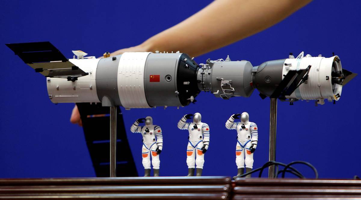A model of the Tiangong-1 space lab module (L), the Shenzhou-9 manned spacecraft (R) and three Chinese astronauts is displayed during a news conference at Jiuquan Satellite Launch Center, in Gansu province, China June 15, 2012. (Image credit: Reuters)