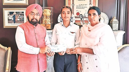 Rajya Sabha member Vikramjeet Singh hands over the cheque to trainee pilot Kulveer Kaur. (Express photo)
