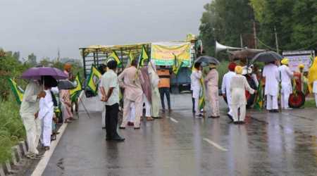 On the call of the Samyukt Kisan Morcha,  members of BKU (Ugrahan) during rain  blocks the Ludhiana-Ferozepur highway at Mullanpur on Sunday. (Express photo by Gurmeet Singh)