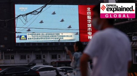 Pedestrians wait at an intersection near a screen showing footage of Chinese People's Liberation Army (PLA) aircraft during an evening news programme, in Beijing, China August 2, 2022. (Reuters Photo: Tingshu Wang)