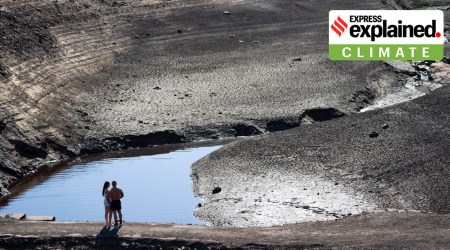 Members of the public stand on what was an ancient packhorse bridge exposed by low water levels at Baitings Reservoir in Yorkshire as record high temperatures are seen in the UK, Ripponden, England, Friday, Aug. 12, 2022. (AP Photo/Jon Super)